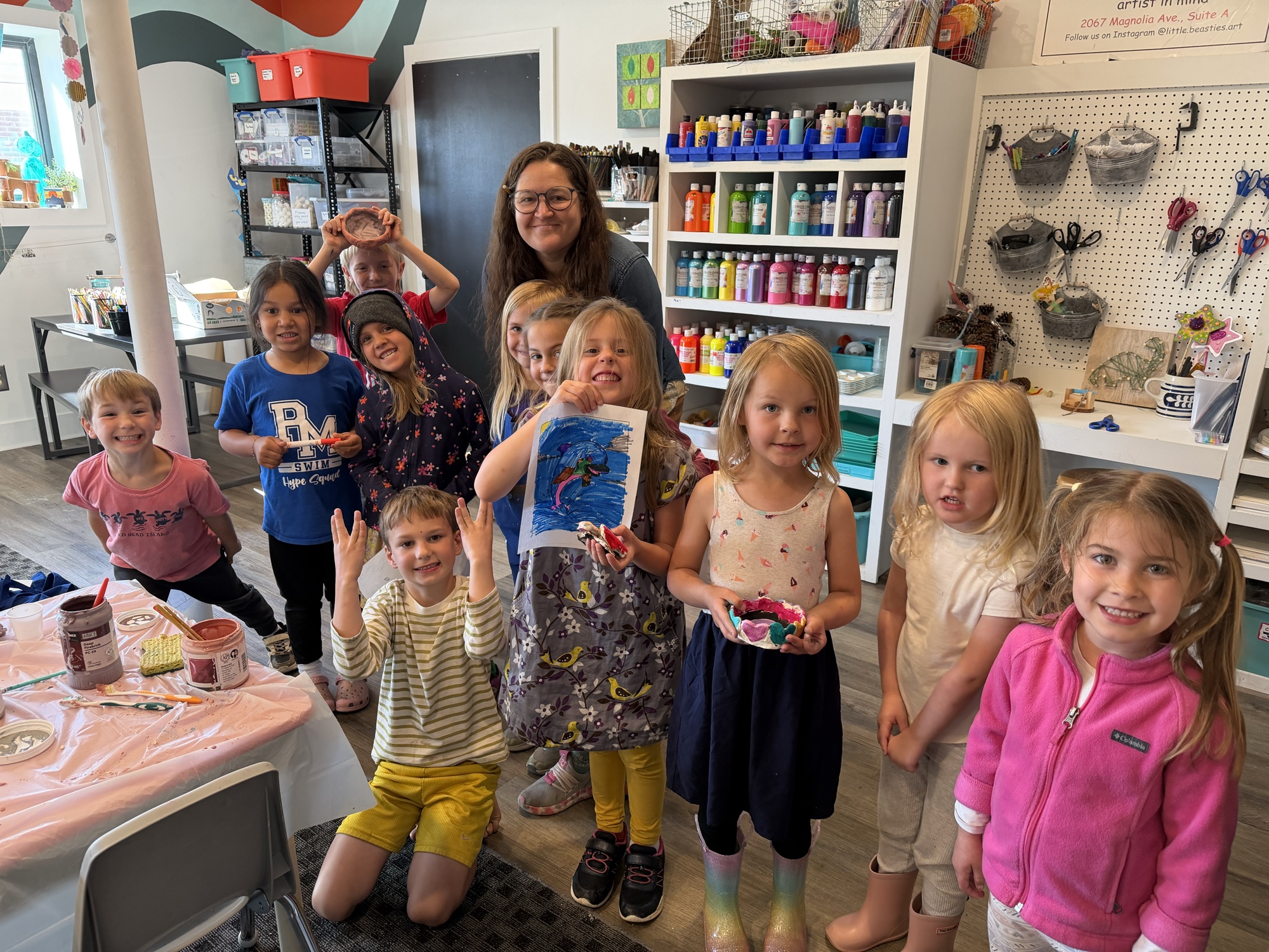 Children and their instructor sharing artwork inside Little Beasties Art Studio